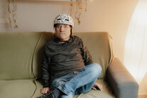 Bewohner des Wohnhauses bei Noh Bieneen sitzt auf dem Sofa