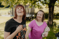 Zwei Frauen spielen im Garten und lachen